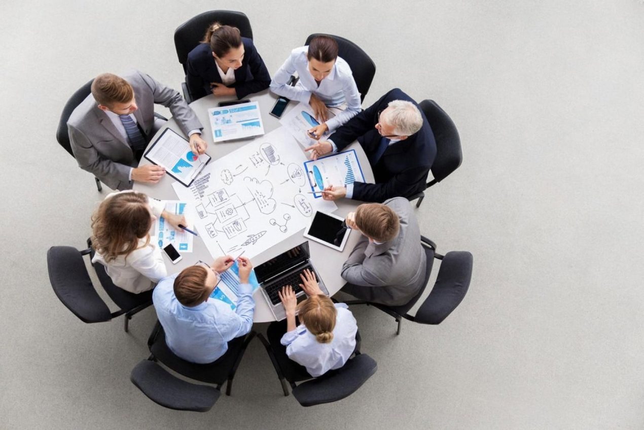 Business team reviewing UAE expansion strategy and compliance documents around a boardroom table