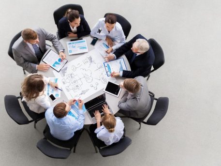 Business team reviewing UAE expansion strategy and compliance documents around a boardroom table