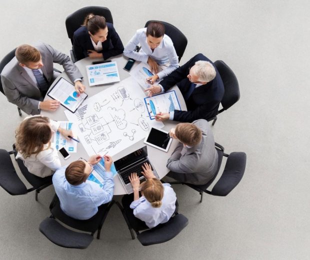 Business team reviewing UAE expansion strategy and compliance documents around a boardroom table